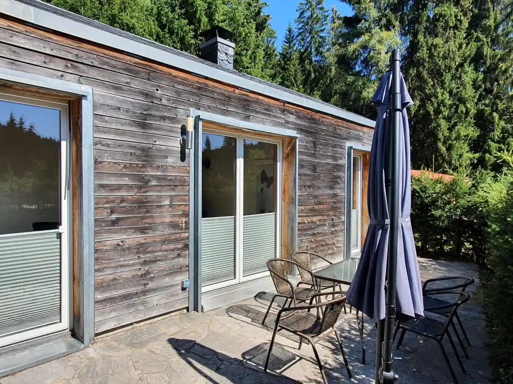 Ferienhaus im Naturcamp Meyersgrund mit Holzfassade, Terrasse und Sonnenschirm