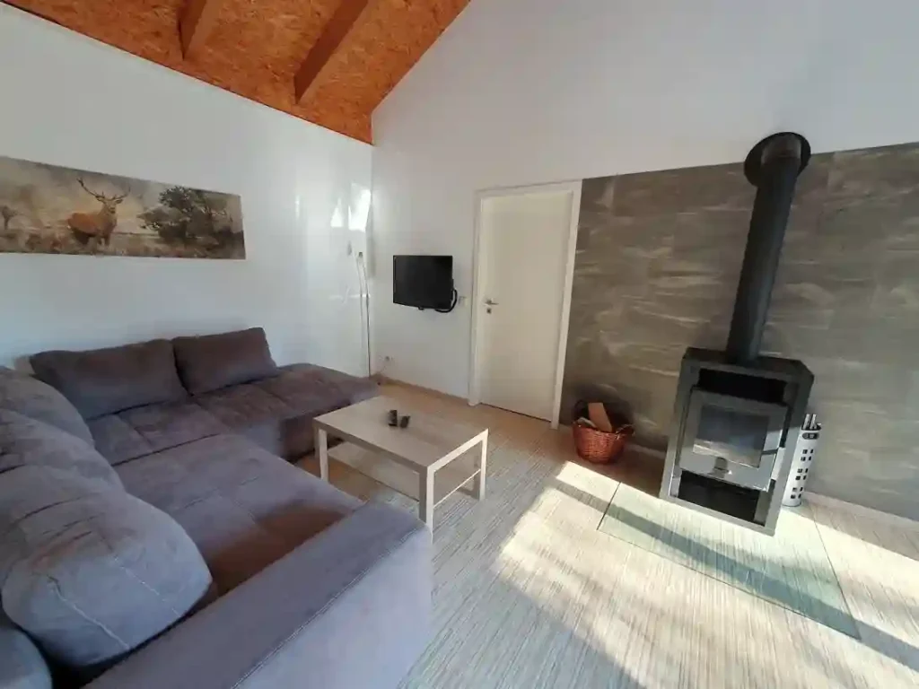 Wohnzimmer im Ferienhaus mit Ecksofa und Kaminofen