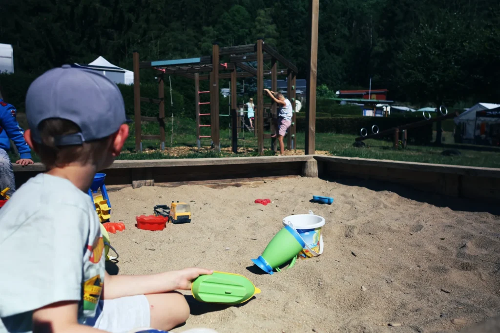Kind spielt im Sandkasten auf dem Campingplatz