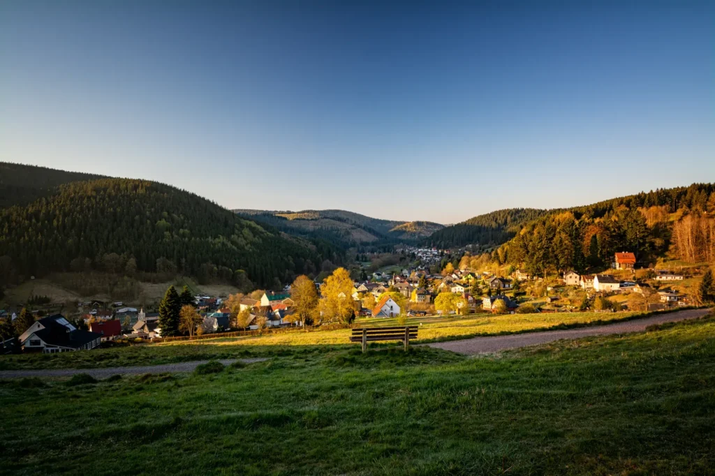 Wanderweg mit Bank und Blick auf Manebach im Abendlicht